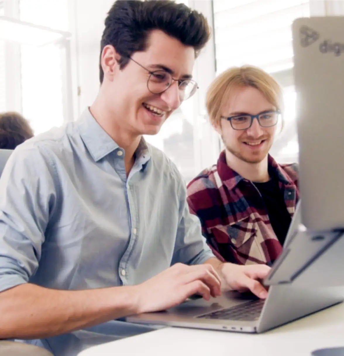 Les collaborateurs de Digio travaillent ensemble sur un ordinateur.